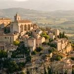 Village perché de Provence au coucher du soleil, maisons de pierre dorée